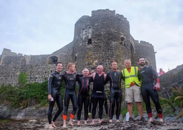The jubilant swimmers with organiser Gary Davision at Carrickfergus Castle on completion of the challenge.