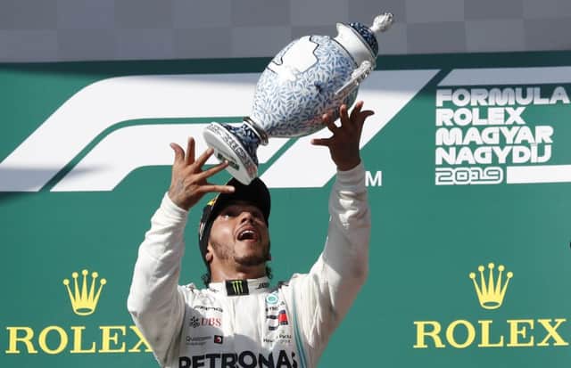 Mercedes driver Lewis Hamilton of Britain celebrates on the podium after winning the Hungarian Formula One Grand Prix at the Hungaroring racetrack. (AP Photo/Laszlo Balogh)