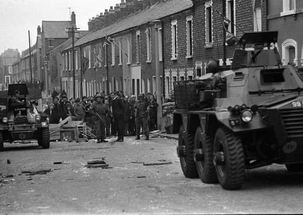 Image from the Troubles. A protestant clergyman is seen talking to a soldier near an armoured car in Disraeli Street, soon after troops had for the first time moved into the protestant area of Belfast. Troops who carried out a house -to-house search discovered a quantity of petrol bombs.