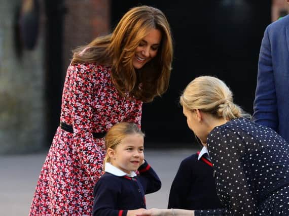 Helen Haslem (right), head of the lower school greets Princess Charlotte as she arrives for her first day of school at Thomas's Battersea in London, with her brother Prince George (hidden) and her parents the Duke and Duchess of Cambridge