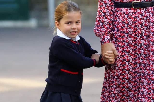 Princess Charlotte holds the hand of her mother, the Duchess of Cambridge, as she arrives for her first day of school at Thomas's Battersea in London.