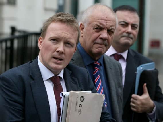 Victims campaigner Raymond McCord (centre) and solicitors Ciaran O'Hare (left) and Paul Farrell outside the Royal Courts of Justice, Belfast