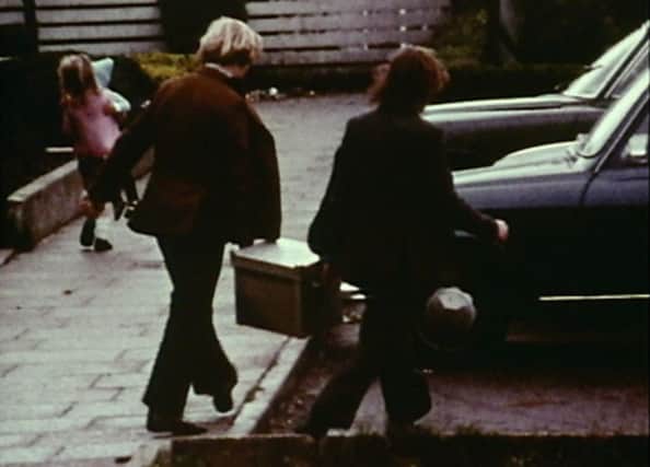 Footage from a lost documentary of two men carrying a bomb used in an attack on the Queen's University Sports Hall in Belfast