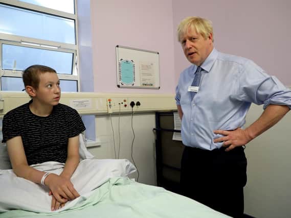 Prime Minister Boris Johnson speaks with Conor, 14, a leukemia patient during a visit to Whipps Cross University Hospital in Leytonstone, east London.
