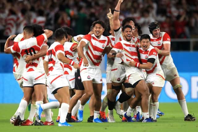 Japan celebrate victory their stunning victory over Ireland.