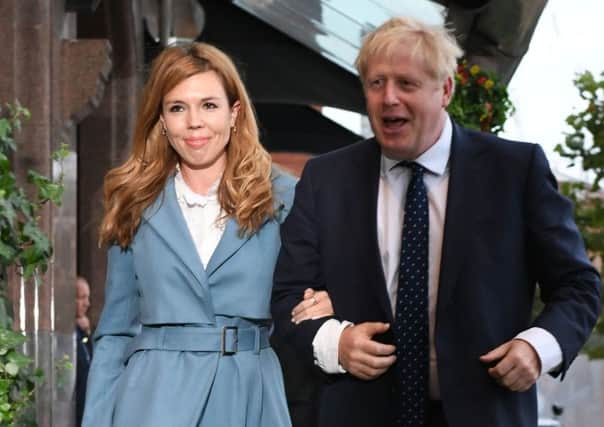 Prime Minister Boris Johnson arrives, accompanied by partner Carrie Symonds, ahead of the Conservative Party Conference in Manchester