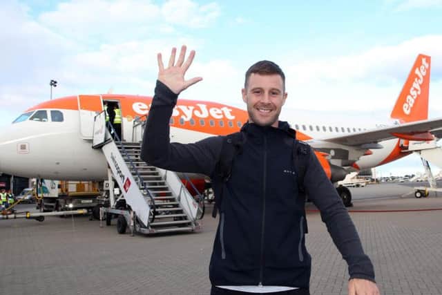 Five-time World Superbike champion Jonathan Rea gives a high-five salute as he arrived home to Northern Ireland at Belfast International Airport on Wednesday.