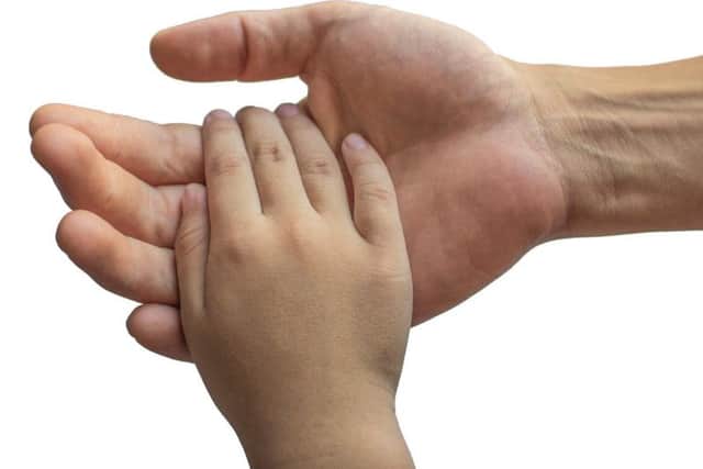 A man holding a child's hand