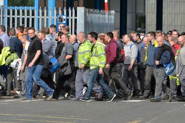 Workers walk out  of Wrightbus