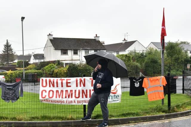 A former Wrightbus employees waits anxiously in the rain near the site of the factory in Ballymena. (Photo: Pacemaker)