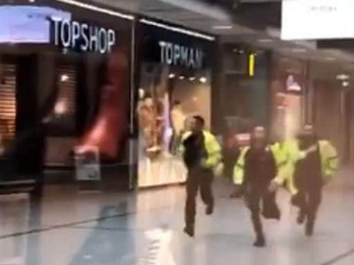 Videograb taken with permission from the twitter feed of @GrizzleMarine showing police running through the Arndale Centre in Manchester where at least four people have been treated after a stabbing incident. (Photo: P.A. Wire)