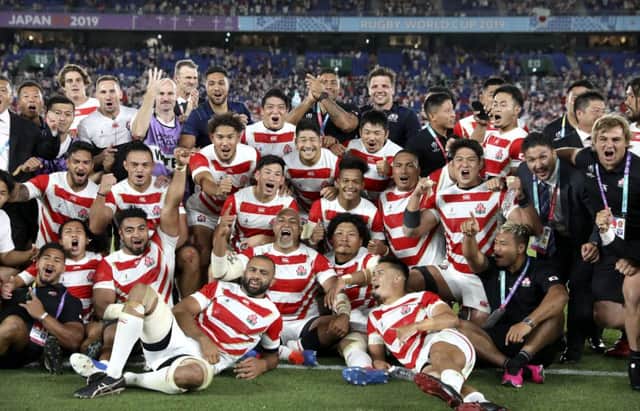 Japan players and management celebrate after defeating Scotland 28-21. (AP Photo/Christophe Ena)