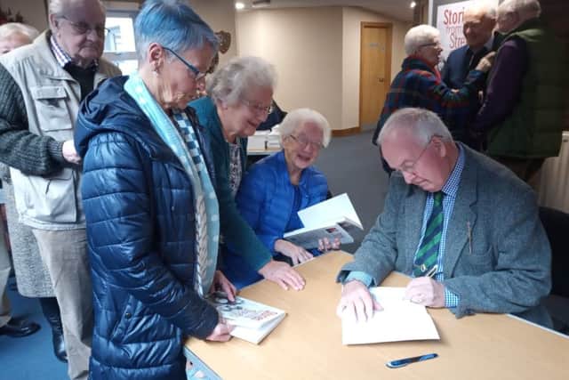 The Rev Jim Rea signs copies of his new book 'Stories from the Streets and Beyond' at a Portadown reception