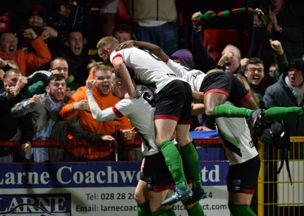 Glentoran players and supporters celebrate Patrick McClean's spectacular overhead kick to seal success over Larne. Pic by Pacemaker.