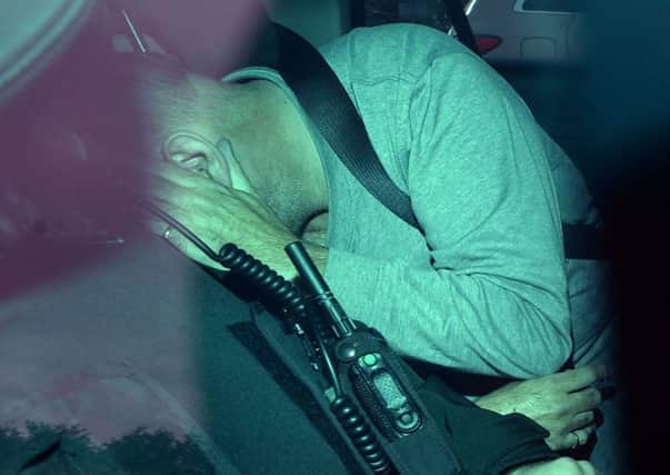 Martin Heaney covers his face as he is driven away from Craigavon Court