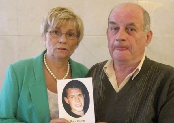 Briege Quinn and Stephen Quinn hold a photo of their murdered son Paul.