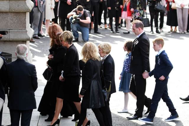 Christine Anderson and family members make their way into St. Eugenes Cathedral for the funeral Mass of her husband Gerry Anderson. DER 3414-0424MT.