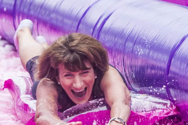St Mary's College principal Marie Lyndsay, enjoying her wet and wild ride down Shipquay Street yesterday during the Slide On For Cancer event. (DER-36-0709-GMI-02-SLIDE)