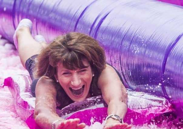 St Mary's College principal Marie Lyndsay, enjoying her wet and wild ride down Shipquay Street yesterday during the Slide On For Cancer event. (DER-36-0709-GMI-02-SLIDE)
