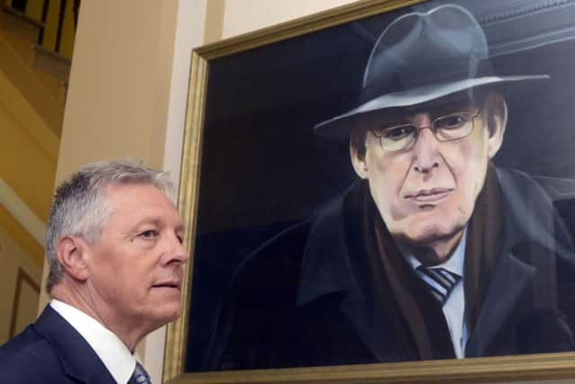 First Minister Peter Robinson,  pauses for a moment at the portrait of the former First Minister which hangs at Stormont.
