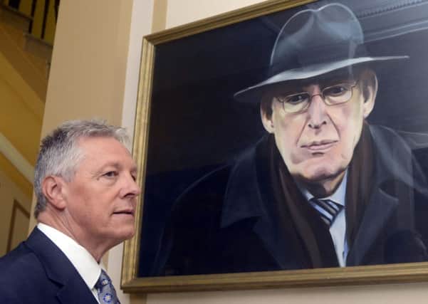 First Minister Peter Robinson,  pauses for a moment at the portrait of the former First Minister which hangs at Stormont.