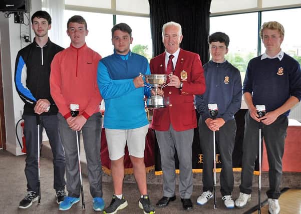 Conor McDiarmid of Fortwilliam GC  receiving the winning team trophy from  Donaghadee GC captain, Colm Fox
