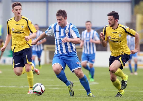 Coleraine's goalscorer James McLaughlin challenged by Dungannon's Dougie Wilson and Dale Montgomery