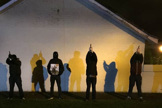 This image is reported to be of masked men firing a volley of shots honouring Declan McGlinchey.
