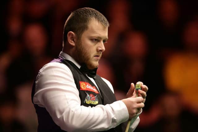 Mark Allen chalks his cue during his match against Barry Hawkins.