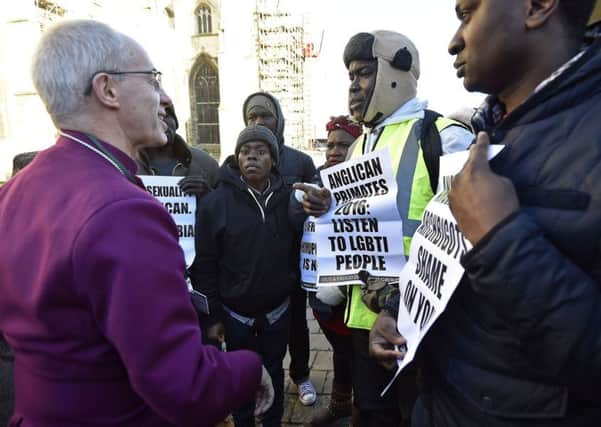 The Archbishop of Canterbury Justin Welby meets gay rights campaigners outside a press conference at Canterbury Cathedral in Kent on Friday