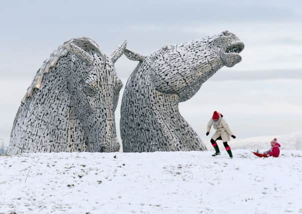 A mother and child sledge at the Kelpies in Falkirk, as a 100-mile wide corridor of snow has seen some Britons waking up to frosty conditions, on Sunday