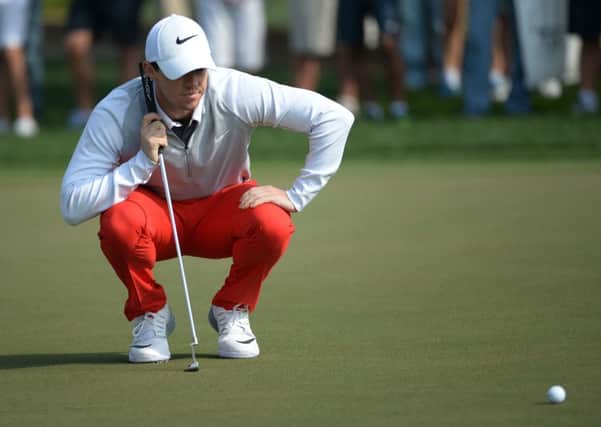 Rory McIlroy  checks the 15th green during the round two of the fog-delayed Abu Dhabi Golf Championship