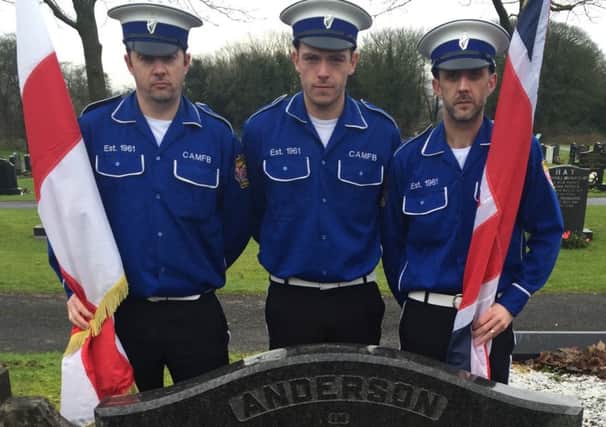 Members of the Constable Anderson Memorial Flute Band committee, William Sharples, Ryan Girvan and Graham Perry, lay a wreath at the grave of Constable Norman Anderson