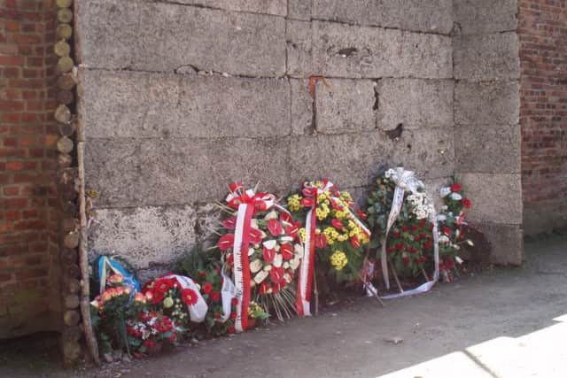 Floral memorials at the notorious execution wall beside the Nazi officers quarters where victims were murdered by firing squad