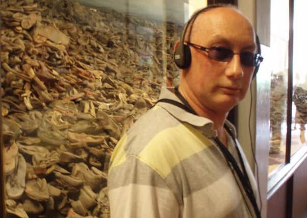 John Coulter beside a memorial composed of the shoes of many of the camps 1.5 million victims