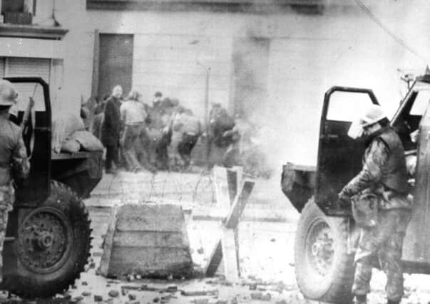 File photo dated 30/1/1972 of soldiers taking cover behind their sandbagged armoured cars while dispersing rioters with CS gas during protests in Londonderry
