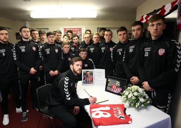 Derry City players sign a book of condolence for Mark Farren at the Brandywell