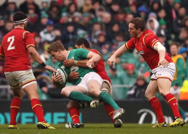 Ireland's Andrew Trimble (centre left) is tackled Wales' Taulupe Faletau