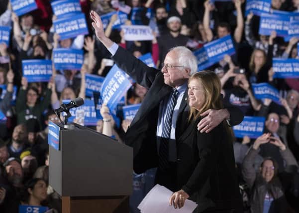 Democratic presidential candidate Sen. Bernie Sanders, I-Vt., center left, waves to the crowd with his wife Jane after speaking during a primary night watch party at Concord High School, Tuesday, Feb. 9, 2016, in Concord, N.H. (AP Photo/John Minchillo)