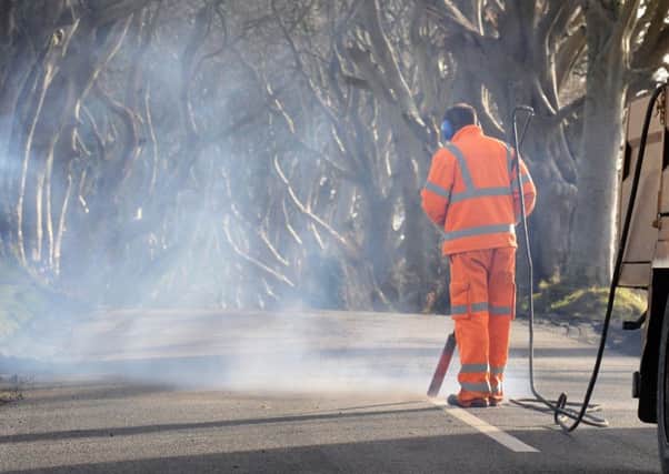 White Lines are removed from the Road at the Dark Hedges,