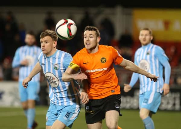 Carrick's Aaron Harmon in action with Warrenpoint's Liam Bagnall.