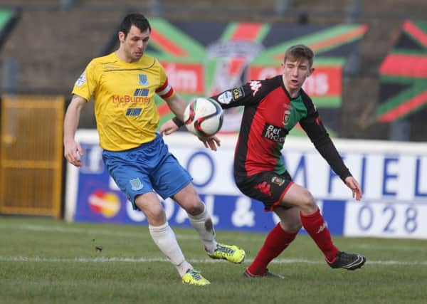 Jonathan Smith in action with Ballymena's Jim Ervin