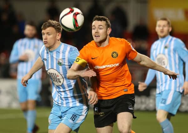 Carrick's Aaron Harmon in action with Warrenpoint's Liam Bagnall