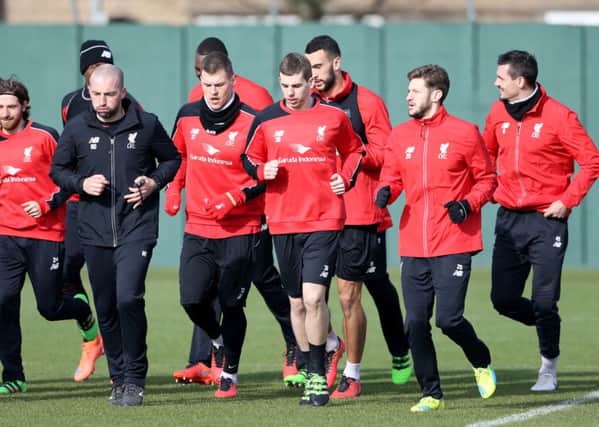 Liverpool's Jon Flanagan (centre) warms up alongside teammates Adam Lallana (second right) and Martin Skrtel  (fourth left) during a training session ahead of the Capital One Cup Final