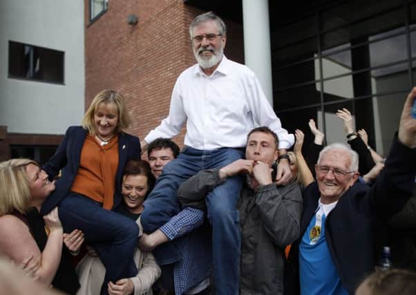 Sinn Fein president Gerry Adams and the partys Imelda Munster are held aloft outside the count centre in Dundalk after being elected representatives for Co Louth