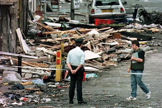 File photo dated 15/08/98 of a Royal Ulster Constabulary police officer looking at the damage caused by a bomb explosion in Market Street, Omagh,  Co Tyrone