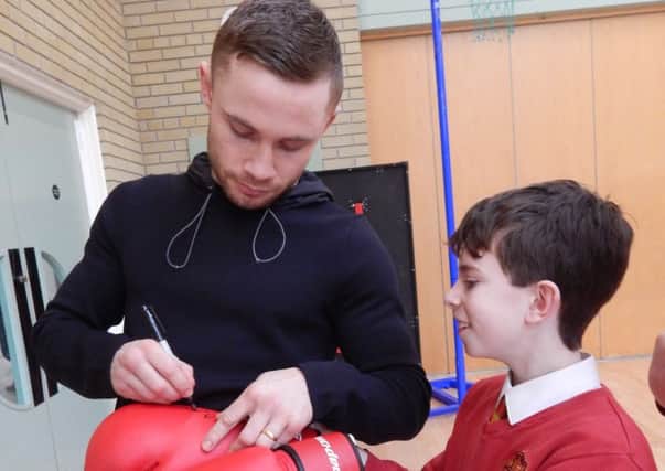 Carl Frampton signs a boxing glove for a pupil at Bridge Integrated Primary School in Banbridge