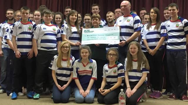 Cheque presentation of Â£1195.30 being received by Margaret Johnston from Macmillan cancer, being presented by club president Trevor Wilson and club secretary Teresa Conon, with club members looking on