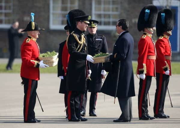 The Duke of Cambridge (centre) prepares to present sprigs of shamrock to the Irish Guards as he visits Cavalry Barracks in Hounslow, west London