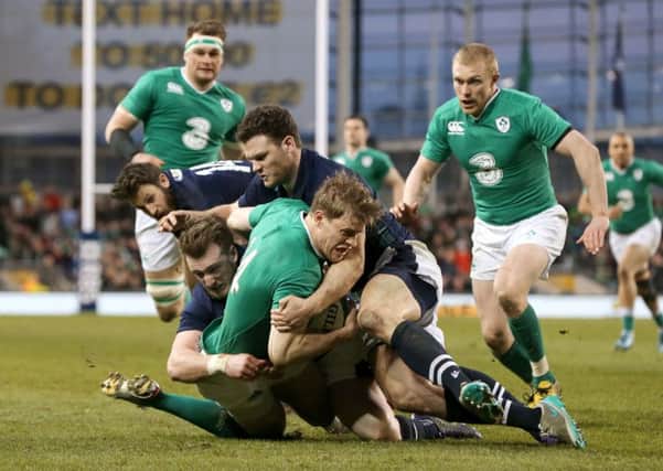 Ireland's Andrew Trimble (centre) is tackled by Scotland's Stuart Hogg (left) and Duncan Taylor